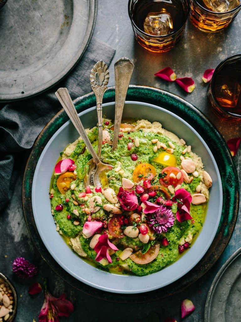 Gesunde Mahlzeit mit Spinat, Eiern, Tomaten, Gurken und Avocado auf einem Teller.